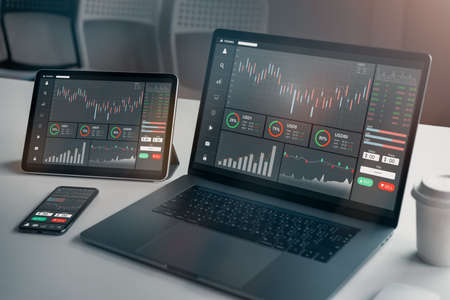 Stock exchange market concept, laptop and tablet, smartphone on the table with graphs analysis candle line in office room, diagrams on screen.の写真素材