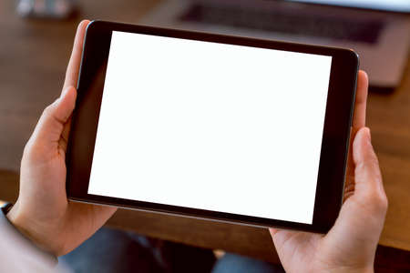 Woman holding digital tablet mockup of blank screen and computer on the table office. Take your...