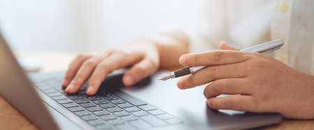 Businessman hands using laptop computer with holding pen and learning various course from online.の写真素材
