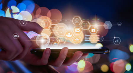 Technology innovation concept, hand holding smartphone and press digital icon with mixed media on...