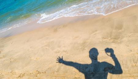 Background of Sand in summer beach holiday with the man traveler and his famous cameraの写真素材