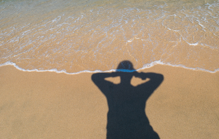 The man shadow of relax time on the beach in the beautiful holidayの写真素材