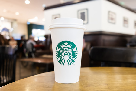 Jakarta, Indonesia, December 31, 2018: View of a paper glass of coffee Starbucks on the wooden table in Grand Indonesia shopping mall, Jakarta, Indonesia.のeditorial素材