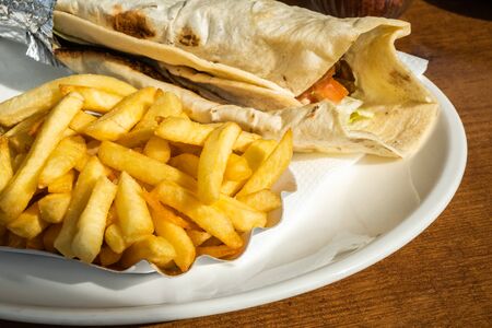 Kebab and French fries recipe on a white dish table in an European country. の写真素材