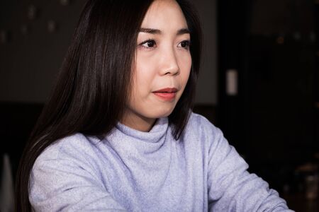 An attractive Asian beautiful female face, a young adult girl with dark hair portrait wear sweet...