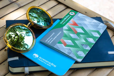 Bangkok, Thailand, May 28, 2020: View of saving deposit passbook bank account on the natural wooden bamboo table, personal money future planing in Bangkok, Thailand.のeditorial素材