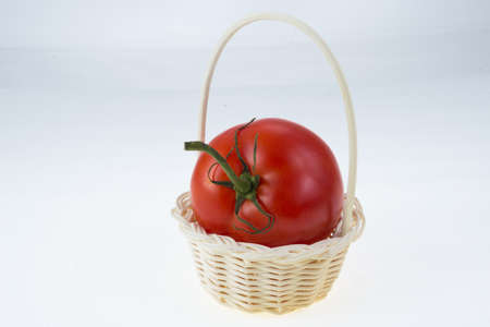 tomatoes in basket on white backgroundの写真素材