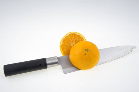 knife and orange on a white backgroundの写真素材