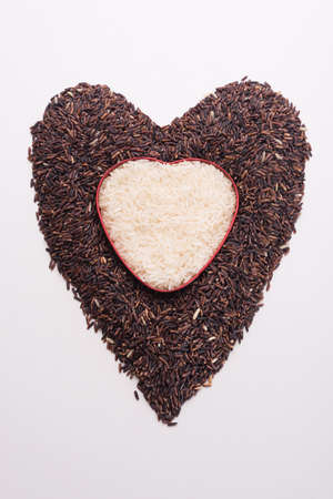 Heart shape from mix of jusmin rice and riceberry rice on white backgroundの写真素材