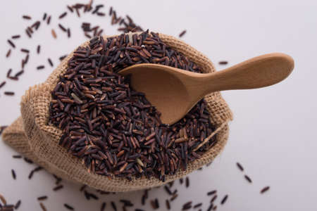 Riceberry rice in sacks top view on a white background.の写真素材