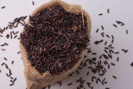 Riceberry rice in sacks top view on a white background.の写真素材