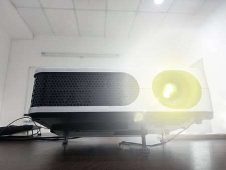 LED projector on wood table in a room projector home theater concept.の写真素材