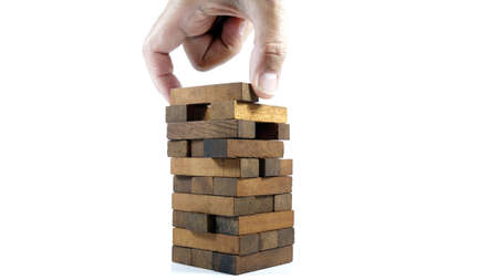 Images of hand of businesspeople placing and pulling wood block on the tower Alternative risk concept plan and strategy in business Risk To Make Business Growth Concept With Wooden Blocks.の写真素材