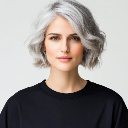 Close up of beautiful woman with white skin, grey short hair, wavy hair and a clear black t shirt, isolated in a light white studio. Portrait person.の素材