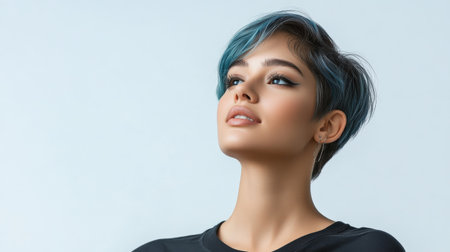 Close up of beautiful woman with white skin, blue short hair, wavy hair and a clear black t shirt, isolated in a light white studio. Portrait person.の素材
