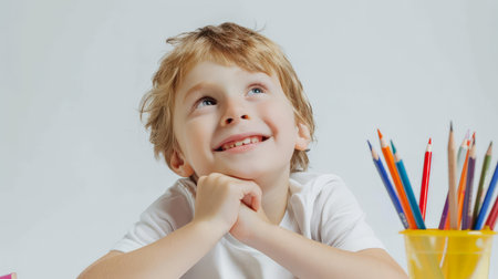 Portrait of a cute little boy with pencils on a white backgroundの素材