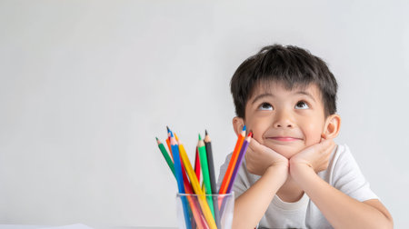 Cute asian little boy drawing with pencils on white backgroundの素材