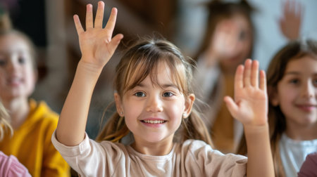 Portrait of smiling little girl raising hands up in classroom at schoolの素材