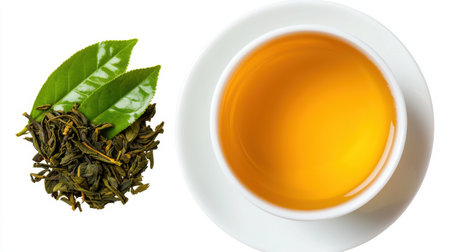 A white cup with a tea leaf on top of it. The cup is filled with a yellow liquidの素材