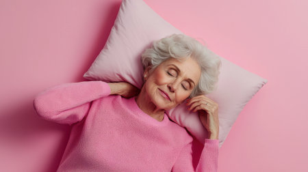 A woman in a pink sweater is laying on a pillow. She is smiling and she is relaxedの素材