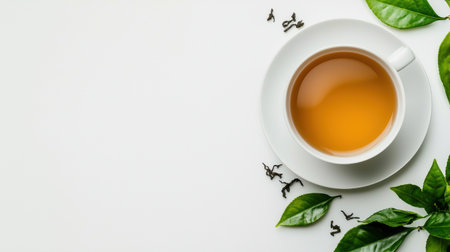 A white cup of tea with a green leaf on the side. The cup is placed on a white backgroundの素材