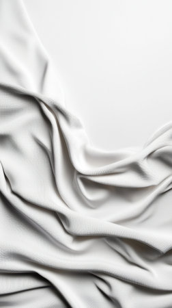 A white fabric is shown in a white background. The fabric is folded and has a texture that looks like it has been crumpled. The image has a minimalist feel to itの素材