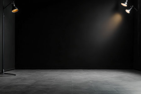 A black room with two lights on the wall. The room is empty and has a very dark atmosphereの素材