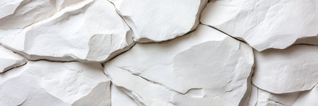 A white rock wall with a few cracks in it. The wall is made of white rocks and has a rough textureの素材