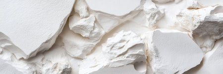 The image is of a white wall with a lot of white rocks scattered all over it. The rocks are of various sizes and shapes, and they are piled up in different areas of the wallの素材