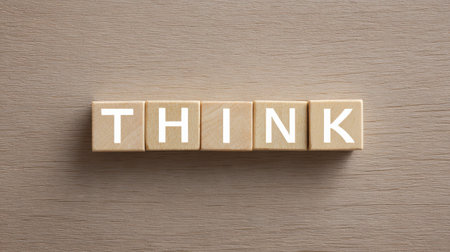 A wooden block with the word "think" written on it. The block is arranged in a way that it looks like a puzzle, with each letter of the word "think" being a separate pieceの素材