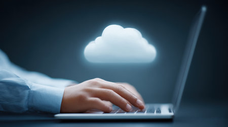 A person is typing on a laptop with a cloud above them. Concept of productivity and focus, as the person is working on a task while the cloud symbolizes the vast amount of informationの素材
