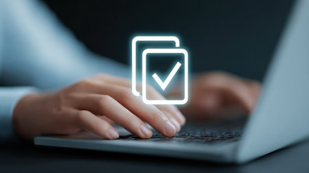 A person is typing on a laptop with a check mark on the screen. The check mark is in the middle of the screen and is surrounded by a squareの素材