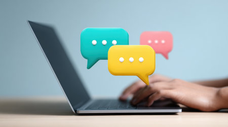 A laptop with a person typing on it and three speech bubbles with a person's hand in the middleの素材