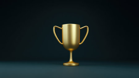 A gold cup with a handle sits on a dark background. The cup is the symbol of achievement and successの素材