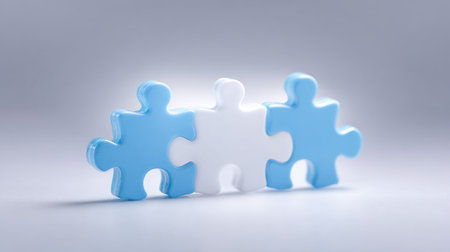 Three puzzle pieces are stacked on top of each other, with one piece being blue and the other two being white. Concept of unity and collaboration, as the pieces fit together to form a complete pictureの素材