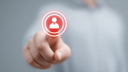 A person is pressing a button that is red and white. The button has a person on itの素材