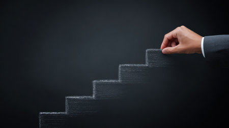 A hand is drawing a chalkboard with a hand on top of a step. Concept of progress and growth, as the hand is reaching for the top of the steps. Scene is one of determinationの素材