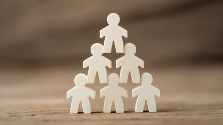 A stack of wooden people with one person on top of the other. The people are all the same size and are all whiteの素材