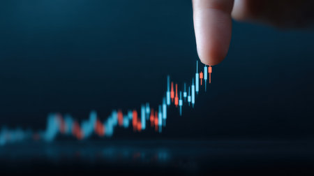 A hand is pointing at a graph with red and blue lines. The graph is showing a rise in numbers, and the hand is indicating that the numbers are increasingの素材