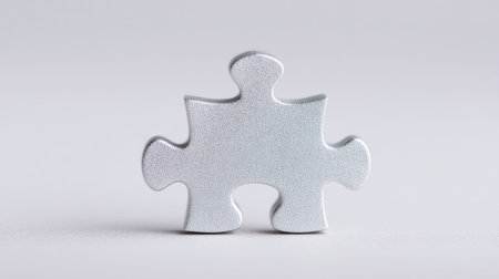 A silver puzzle piece is on a white background. The puzzle piece is missing a corner, which gives it a sense of incompleteness. Concept of a puzzle that is not yet solvedの素材