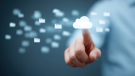 A person is pressing a button on a computer screen that has a cloud icon on it. Concept of technology and the importance of data storageの素材