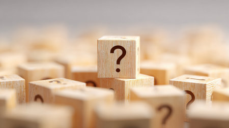 A pile of wooden blocks with a single block that has a question mark on it. The blocks are all different sizes and shapes, but the one with the question mark stands out as the focus of the imageの素材