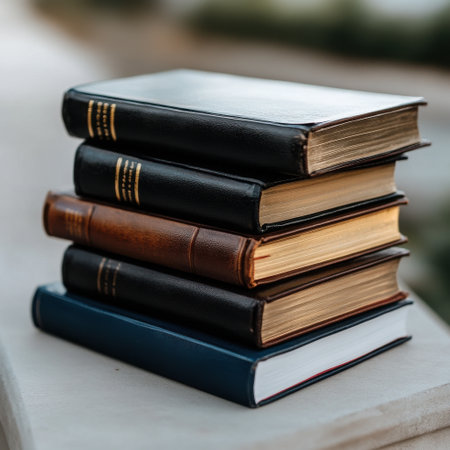 A stack of books with the top book being a Bible. The books are all black and brownの素材