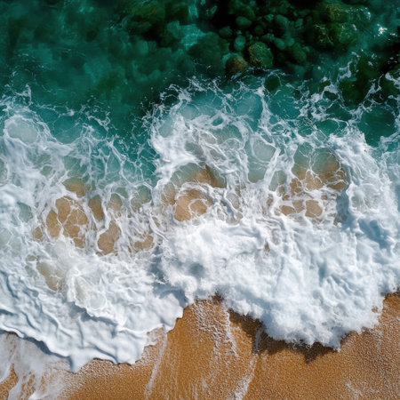 The ocean waves are crashing against the shore, creating a beautiful and calming scene. The water is a deep blue color, and the rocks in the background add a sense of depth and texture to the imageの素材