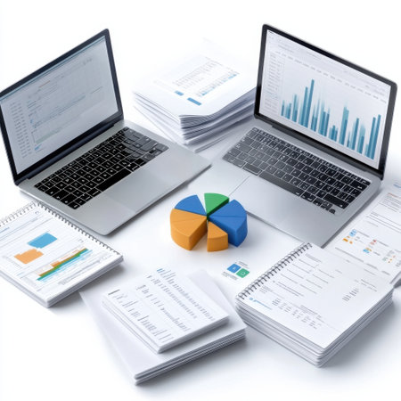 A laptop and two other laptops are on top of a table with a stack of papers and a pie chartの素材