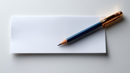 A blue pencil is on top of a blank piece of paper. The pencil is sharpened and ready to be used. The paper is white and has a blank space for writing. Concept of readiness and preparednessの素材