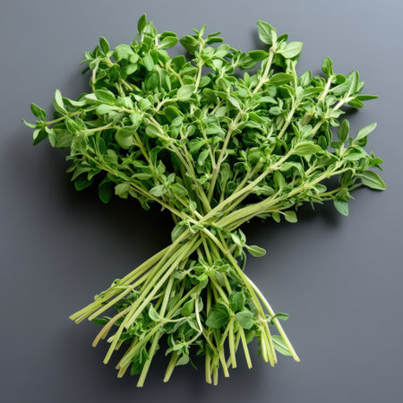 A bunch of green herbs are piled up on a table. The herbs are fresh and green, and they look like they are ready to be used in a recipe. Scene is one of freshness and abundanceの素材