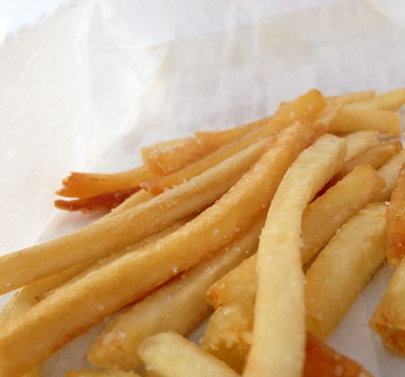 Tasty french fries on wooden table background