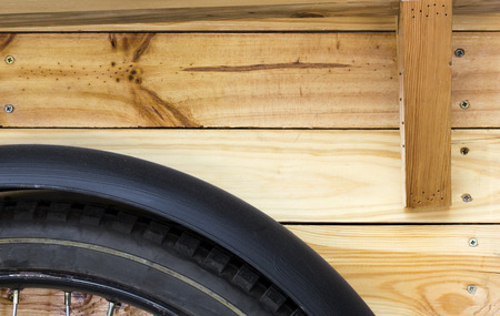 Close-up bicycle wheels on wooden floor background.