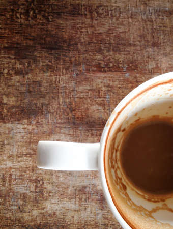 Coffee cup with coffee stains have not washed the cup placed on woodenの写真素材